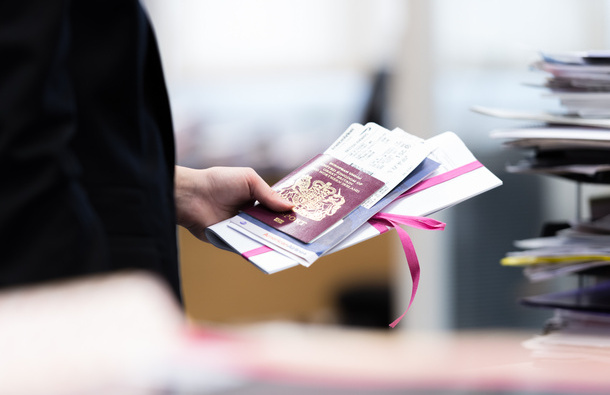 Person holding a British passport with other papers.