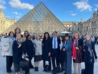 Photo of a group of people in front of the Louvre