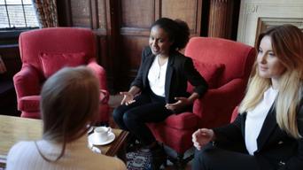 Three women sit in a chambers over tea