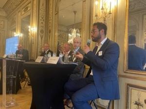 A panel discussion set in the residence of the UK ambassador to the EU. One person is speaking with a microphone. 